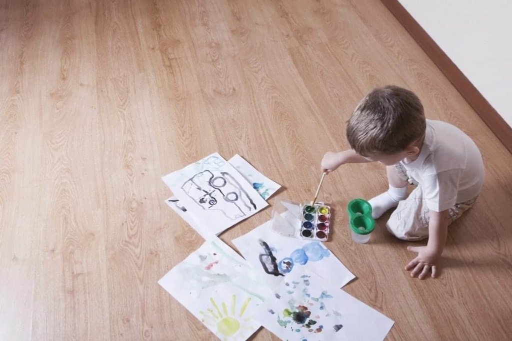 young boy painting on floor