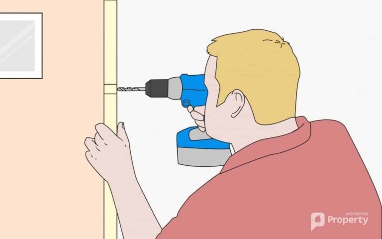 man drilling holes on a door