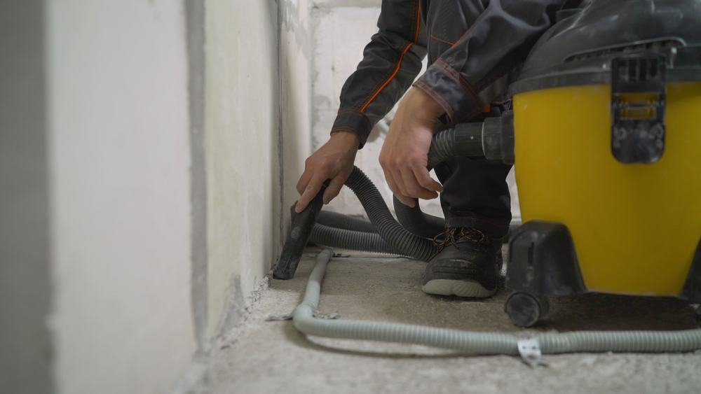 man vacuuming concrete floor