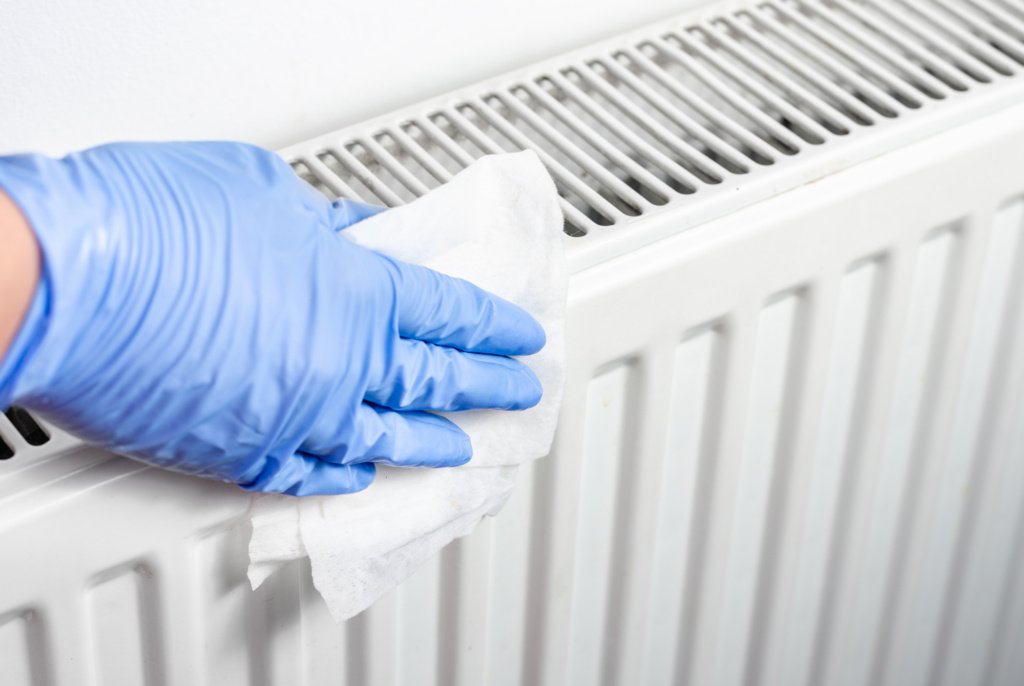man with surgical gloves cleaning a radiator