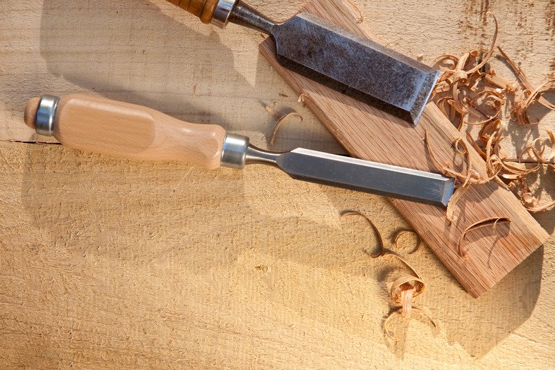 two different size chisels above a block of wood