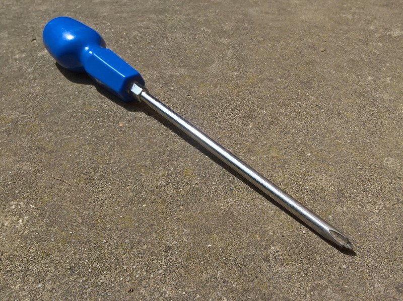 pozidriv screwdriver with blue handle laying on the floor