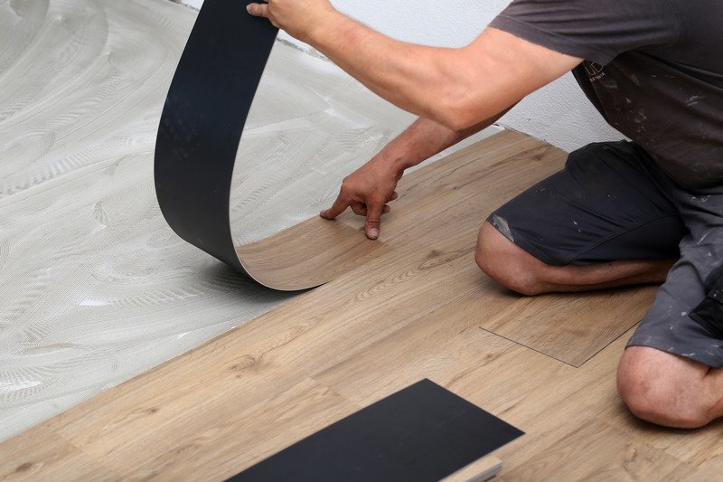 worker installing new vinyl plank floor