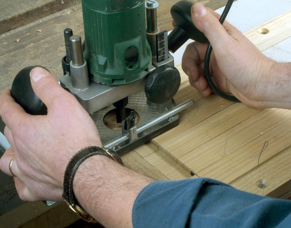 male woodworker using an electric routing tool