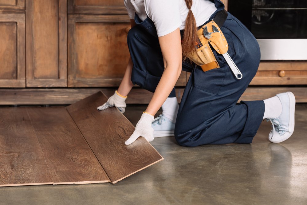 female worker installing laminate flooring