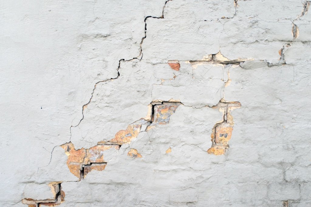 cracks on a wall showing brickwork