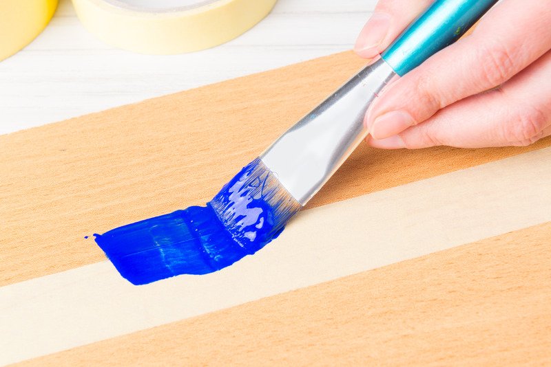 applying blue paint with paintbrush