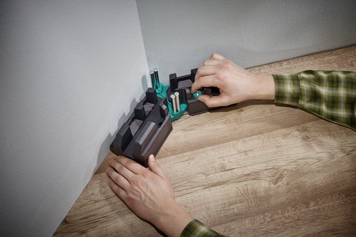 man setting up mitre box in corner of the wall