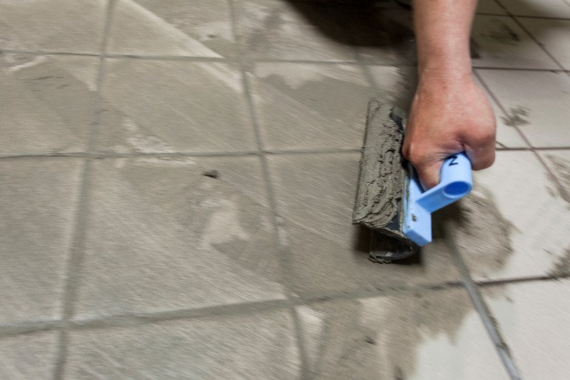 builder laying tile grout