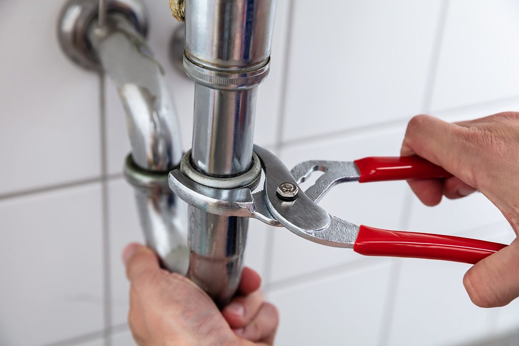 plumber using adjustable pliers