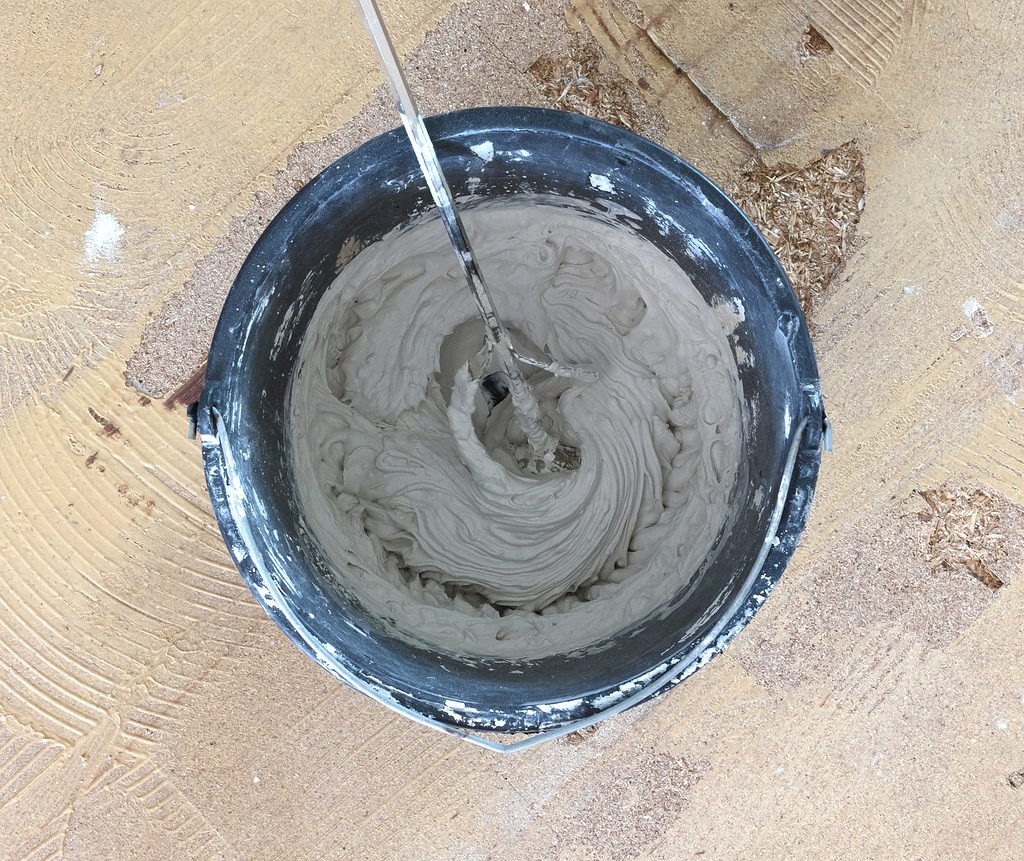 mixing concrete in a bucket using a paddle mixer