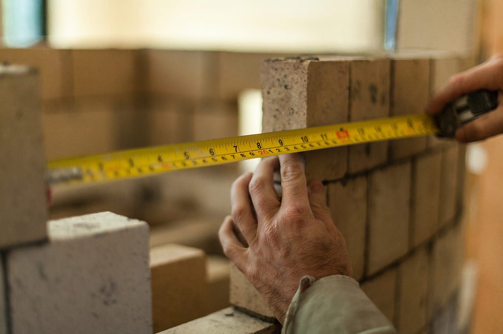 bricklayer using a tape measure