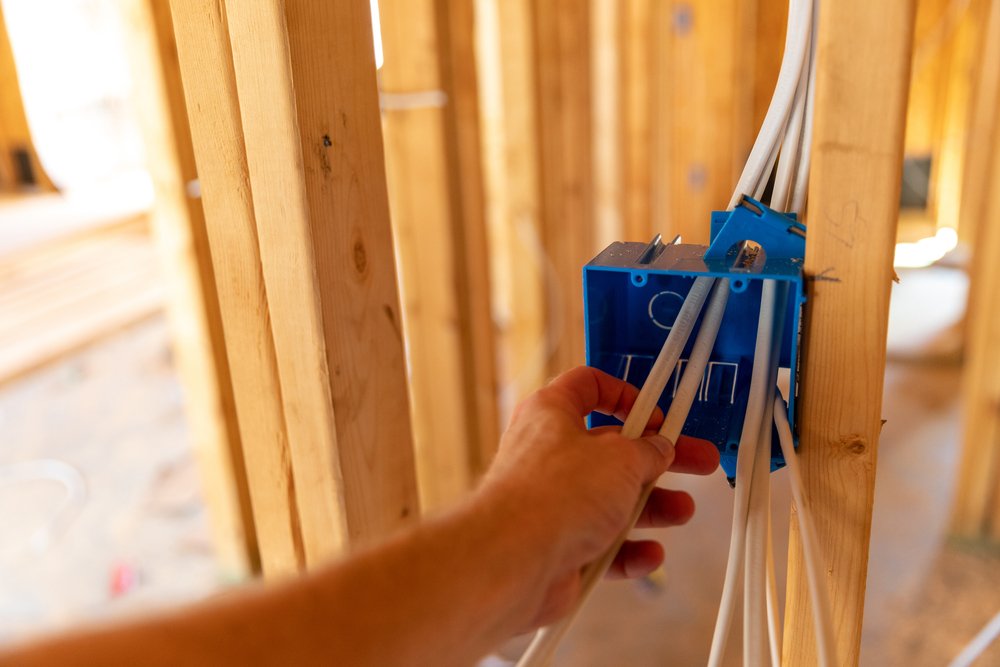 electrician working on electrical wires in new home construction