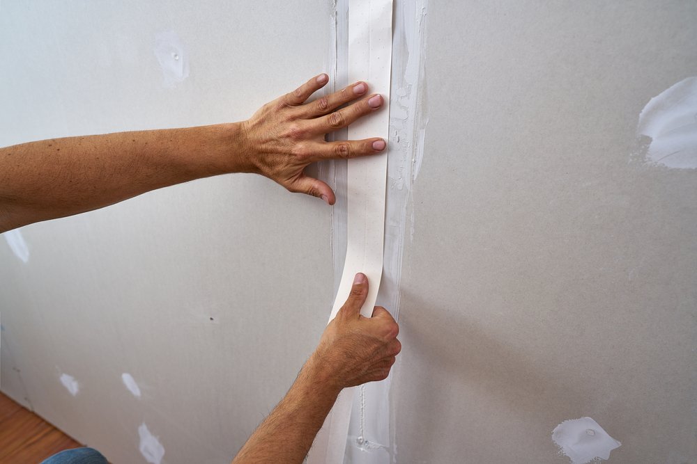 man taping plasterboard