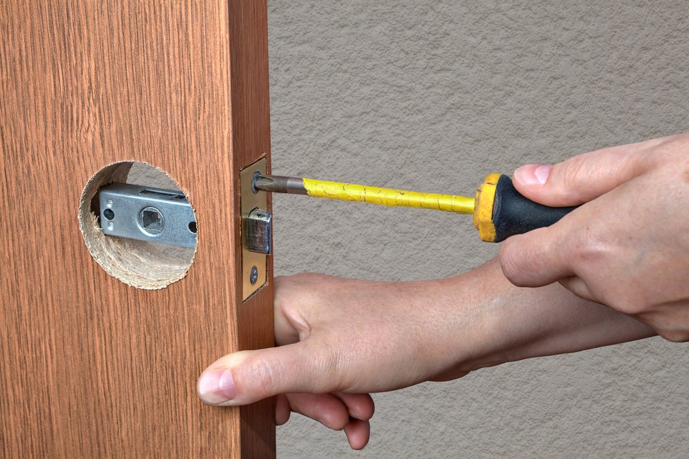 carpenter securing face plate on a door