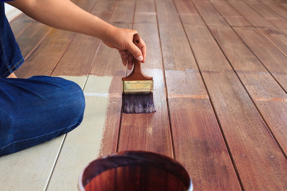 man painting wood flooring