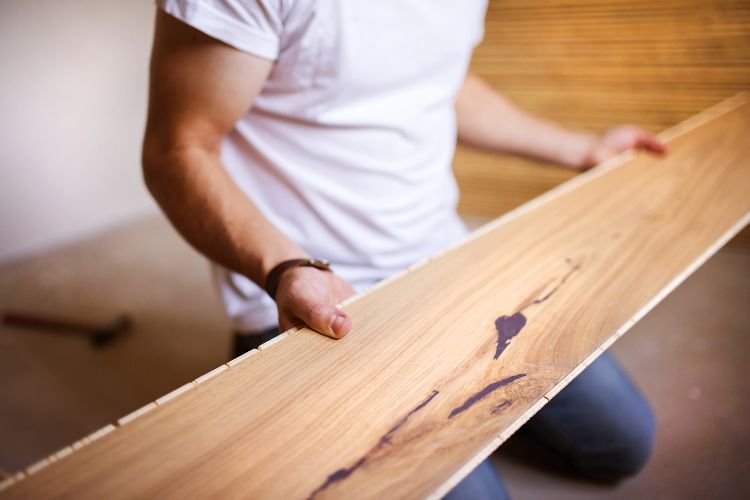 carpenter positioning solid wood flooring plank