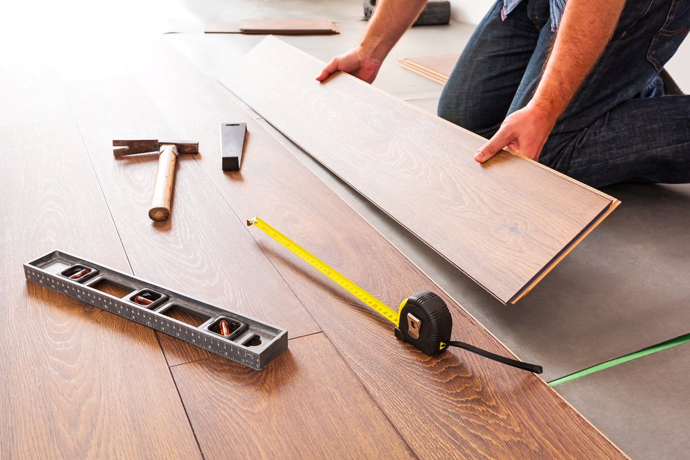carpenter laying solid wood flooring