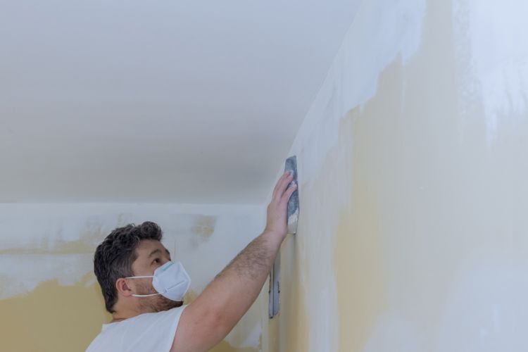 painter applying plaster on bathroom wall
