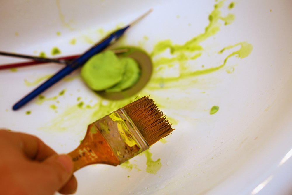 cleaning paint brush in sink