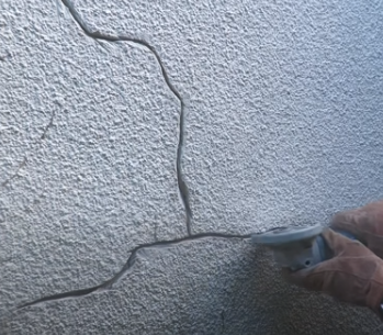 painter grinding out cracks using angle grinder
