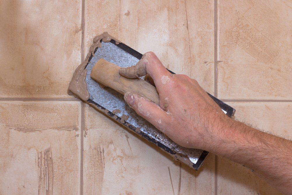 carpenter applying grout to tiles