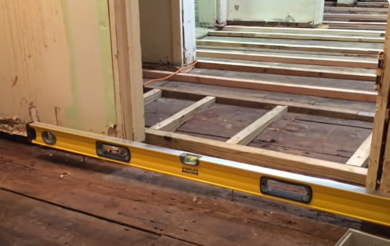 levelling unfinished sloped wood flooring using level